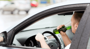 muž pijúci alkohol za volantom