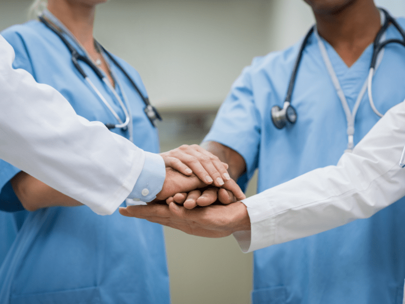 4 lekári majú ruky pokope na znak súdržnosti